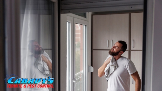 Man wiping sweat in humid home